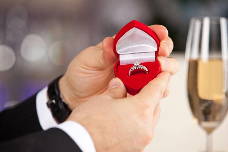 男人用手打开订婚戒指盒