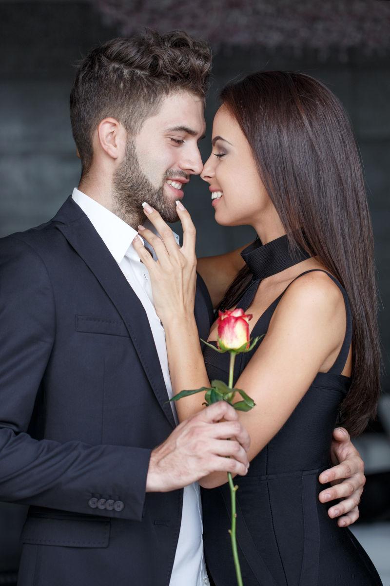 年轻的时尚男人在情人节给女友玫瑰献