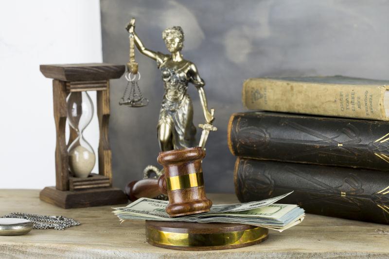 拍卖桌上的正义女神雕像和美钞