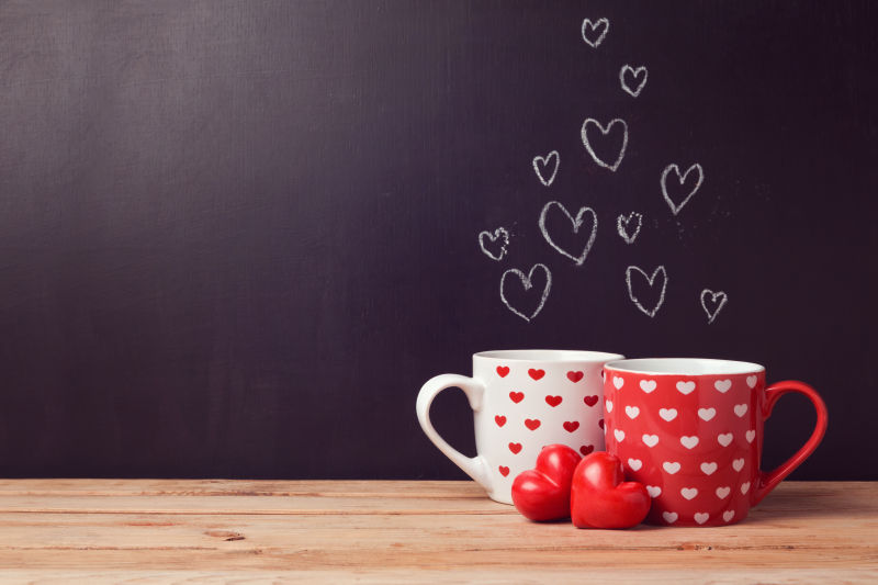 黑板上画心和两个心形杯子的情侣情人节概念