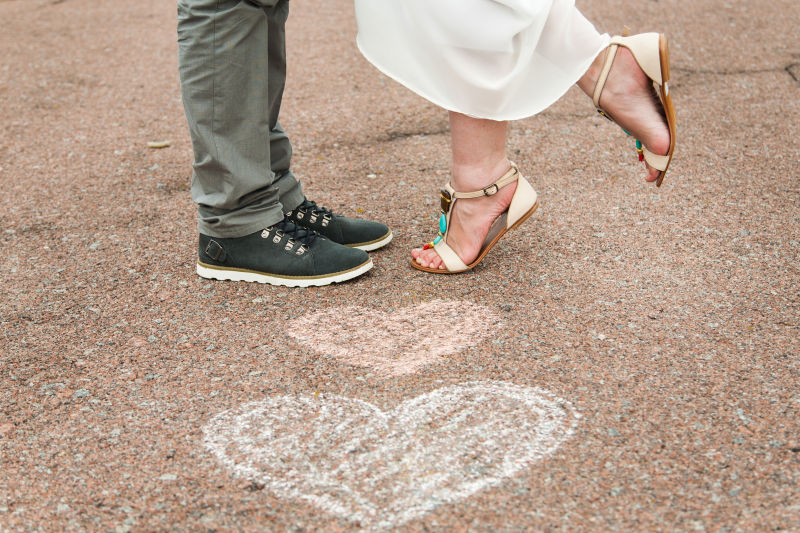 地面上的两个心形和年轻夫妇的脚