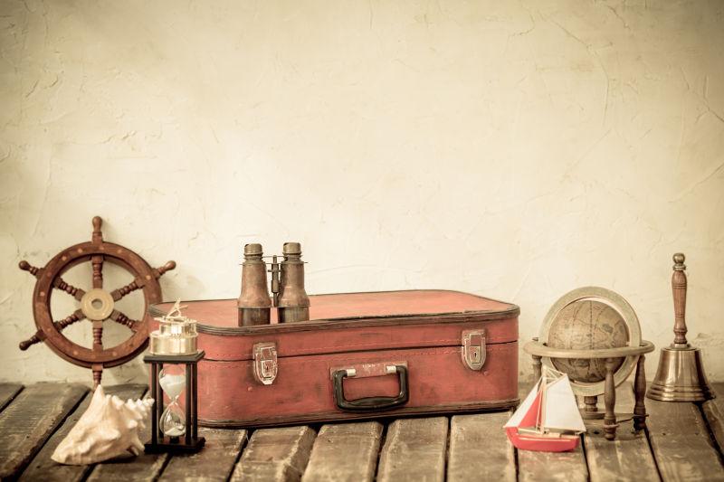 木制板上的老式的手提箱与古董