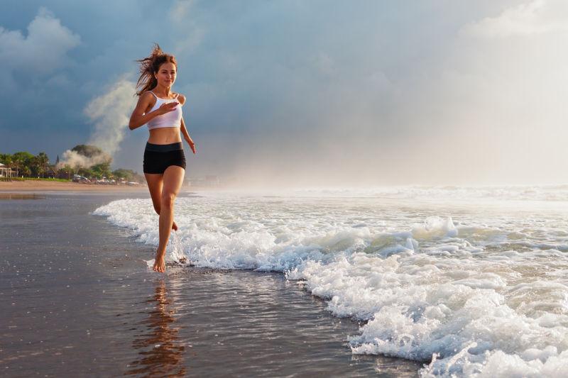 在海边跑步健身的年轻美女