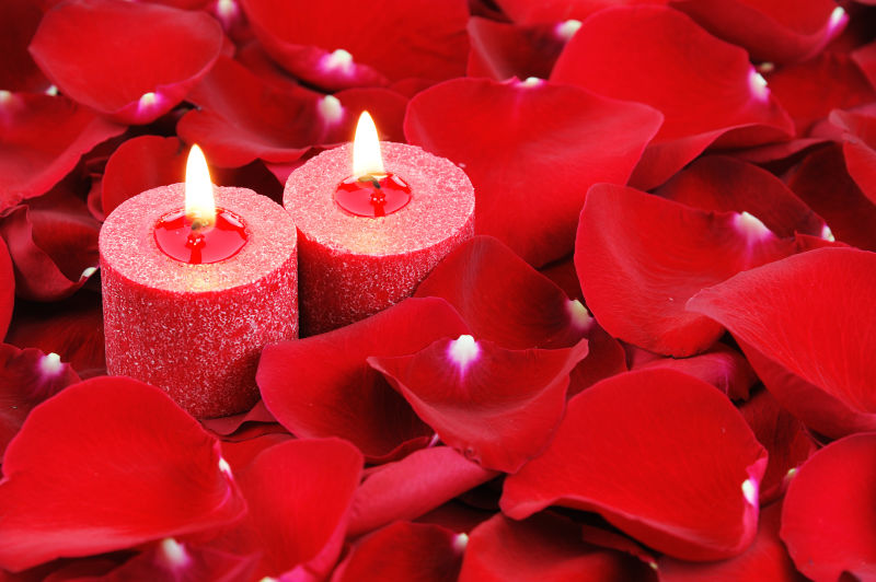 红蜡烛和玫瑰花瓣背景