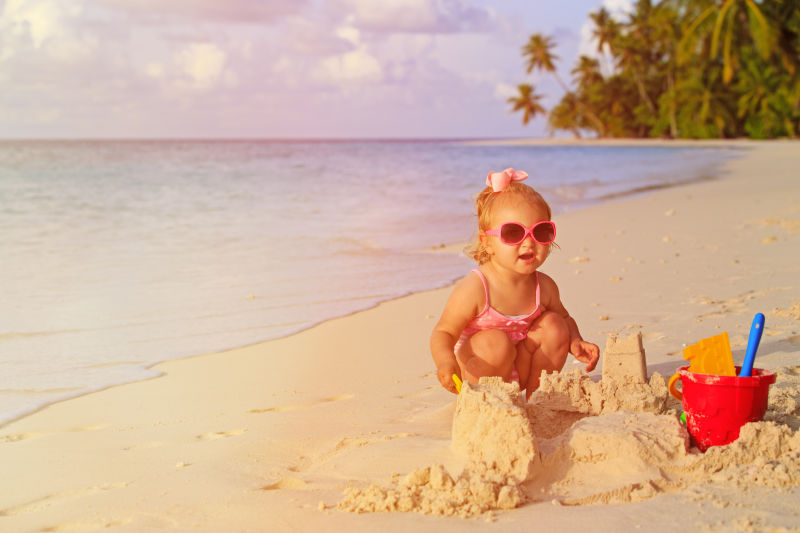可爱小女孩在沙滩上玩沙子