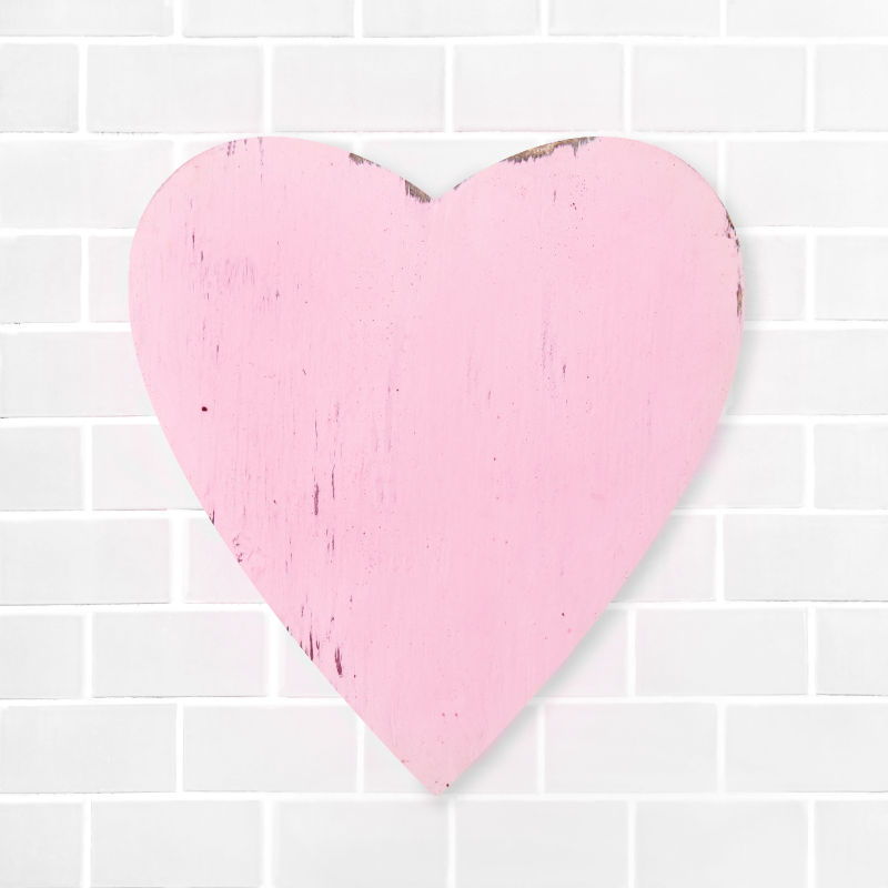 粉色的心在白砖墙的背景下