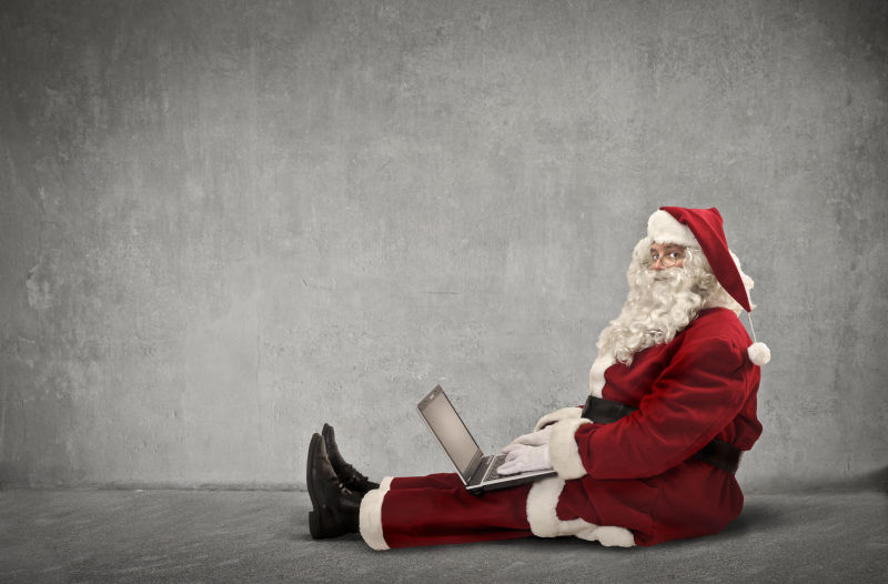 圣诞老人坐在地上玩电脑