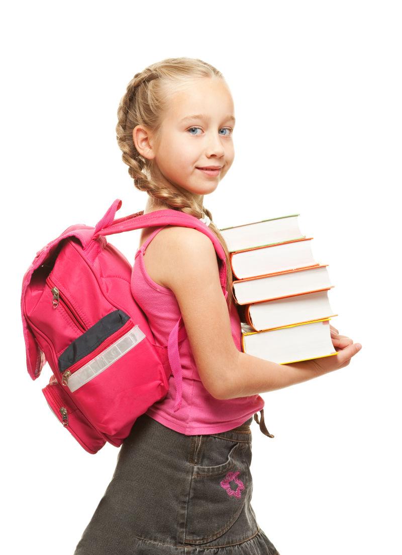背着书包拿着书的小女孩