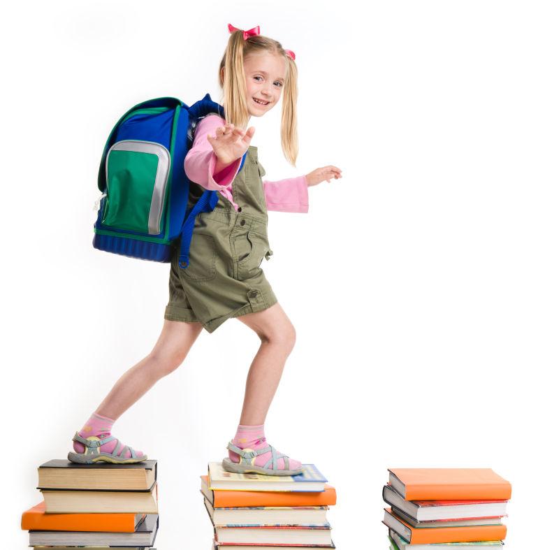 背着书包走在书上的小女孩