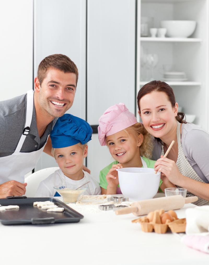 一个快乐家庭的画像在厨房里做蛋糕