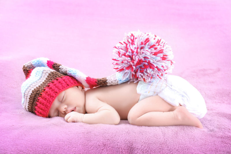 趴在粉色毛绒毯上入睡的宝宝