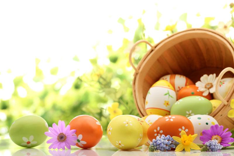 黄色水仙花背景下木桶里倒出来的复活节彩蛋