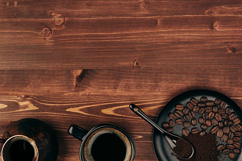 棕色的老木板背上的黑咖啡和咖啡豆