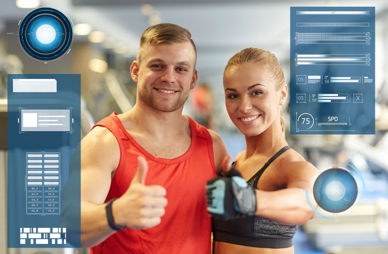 微笑的男人和女人在虚拟图表上显示健身房的拇指