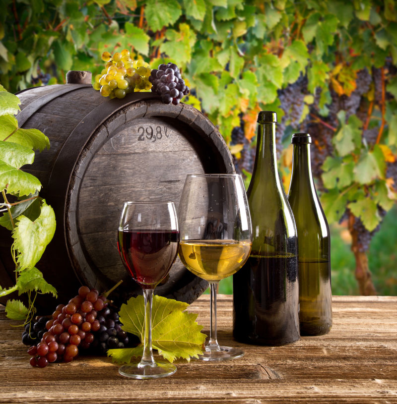 木桌上的葡萄酒与葡萄酒桶