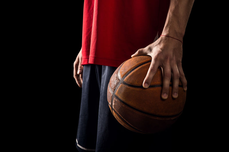 球员在黑色背景中手持篮球球