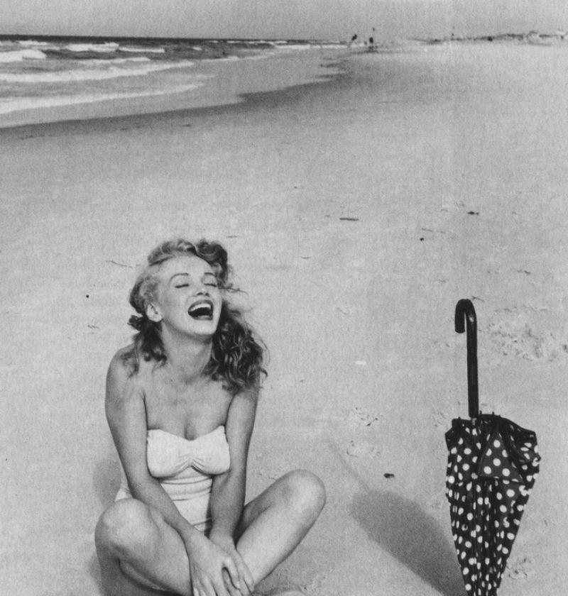 坐在沙滩上性感美女在大笑