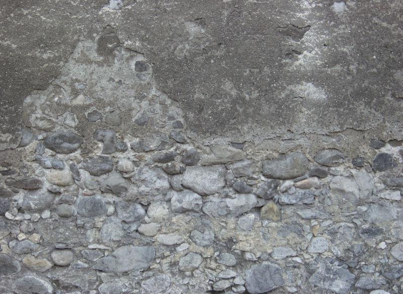 水泥脱落漏出里面的石子石墙背景