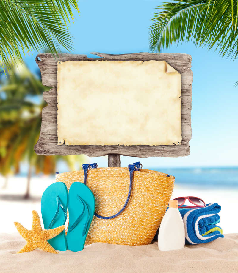热带海滩上的木制板与旅游用品