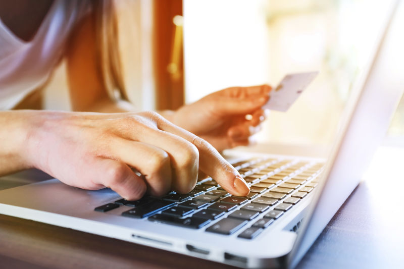 女子与笔记本电脑在网上用信用卡在网上购物