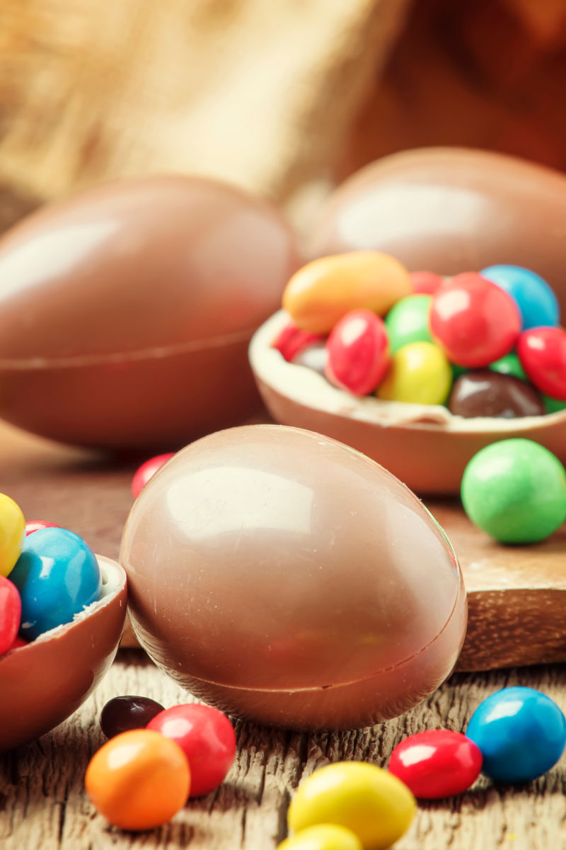 复活节用巧克力蛋和彩色糖果古董木制背景选择性聚焦