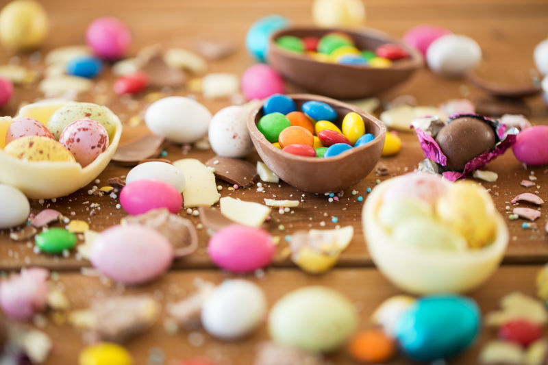 复活节垃圾食品糖果和不健康的饮食观念-巧克力蛋和糖果滴在桌子上的特写镜头