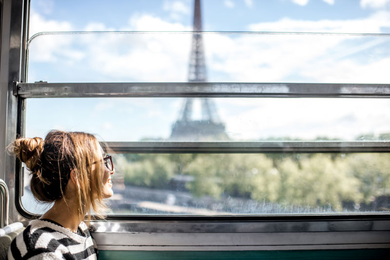 从巴黎的火车窗口望着埃菲尔铁塔的年轻女子