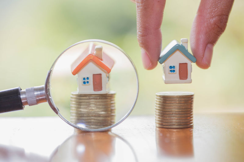人手里拿着房子上的硬币-计划着存钱的硬币买一套房子的概念-抵押和房地产投资-为房子储蓄或投资