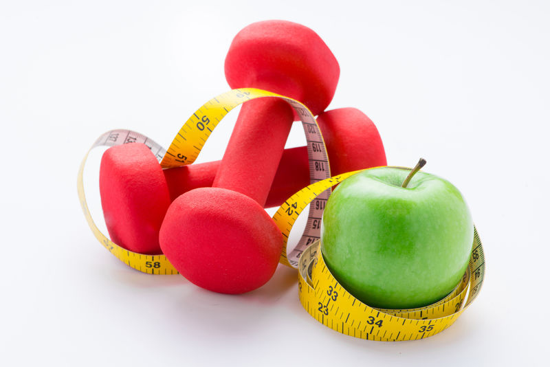 健身哑铃和水果-鲜绿可口的苹果-白色绝缘胶带