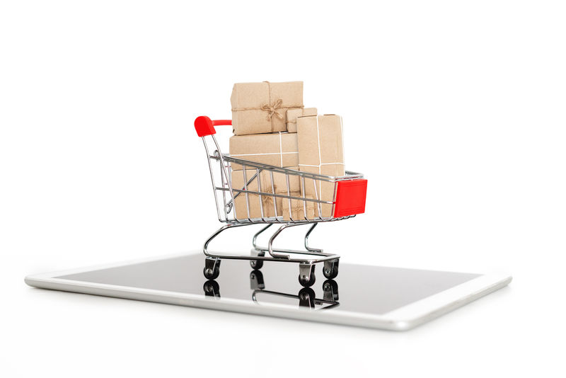 网上购物和网上购物-购物车上满是数字平板电脑上的盒子-白色背景隔离