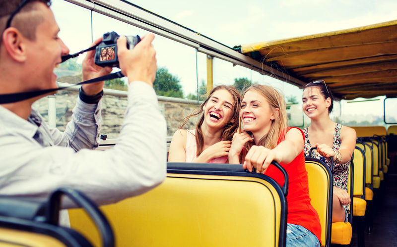 友谊旅行度假暑假和人的概念——带相机的欢笑朋友乘坐旅游巴士旅行