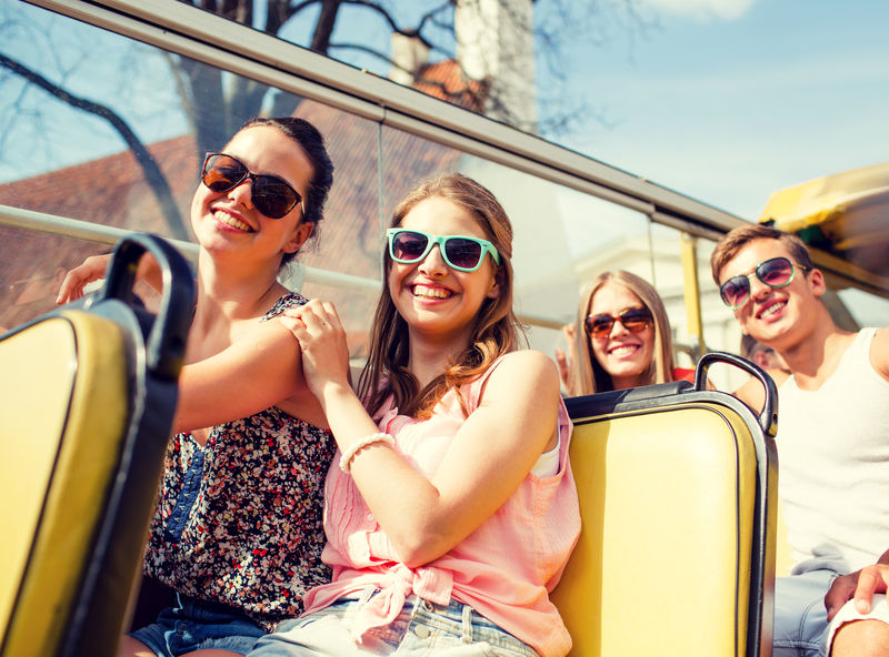 友谊旅游度假暑假和人的概念-旅游巴士上微笑的朋友群