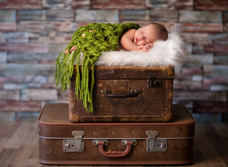 睡在乡村手提箱上的新生婴儿