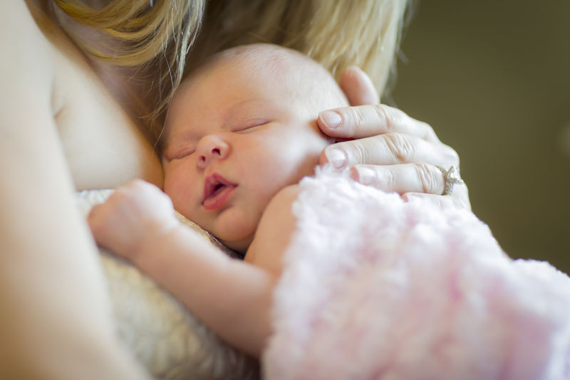 母亲抱着刚出生的女婴的手