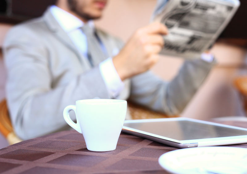 商务男性手触数字平板电脑特写-正式商人桌上有咖啡杯