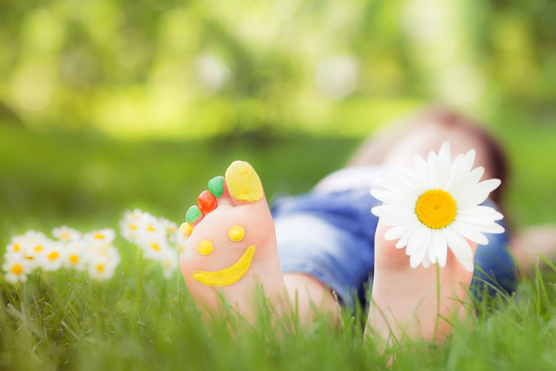 孩子躺在青草上-在春天公园玩得开心的孩子