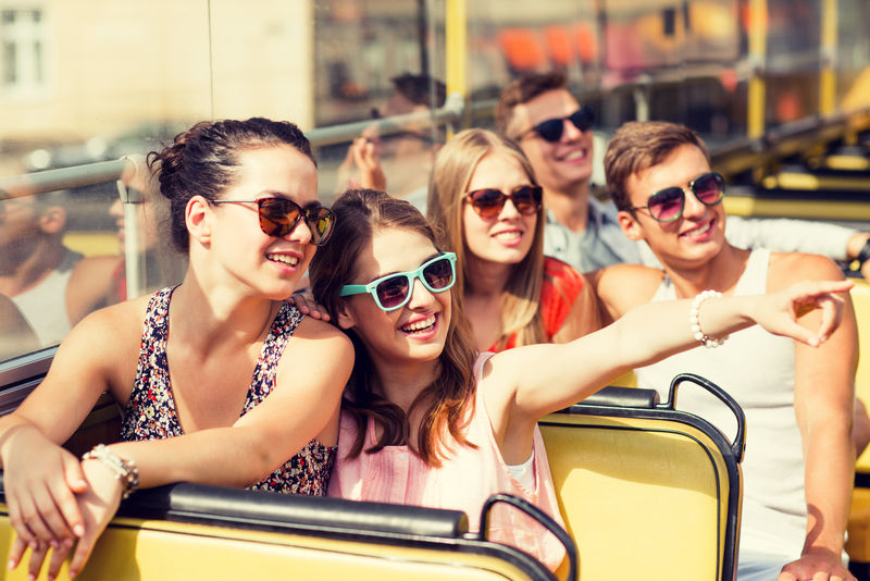 友谊旅游度假暑假和人的概念-旅游巴士上微笑的朋友群