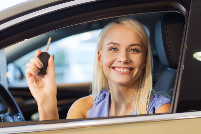 汽车生意汽车销售消费主义和人的观念——从汽车展或沙龙的经销商那里拿车钥匙的快乐女人