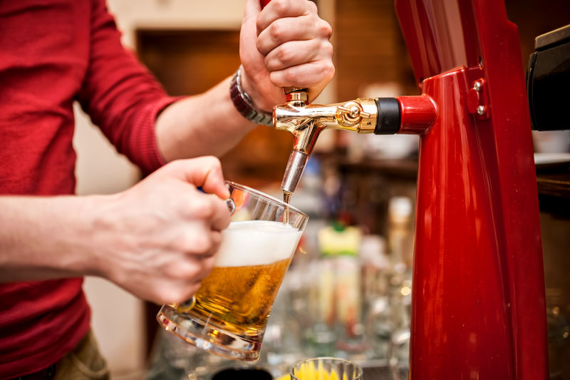 酒吧招待在酒吧或酒吧里酿造未经过滤的生啤酒