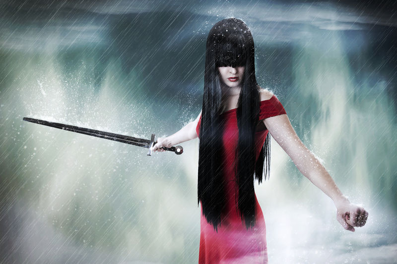 年轻漂亮的黑发女人在雾中剑斗士的时尚幻想画像