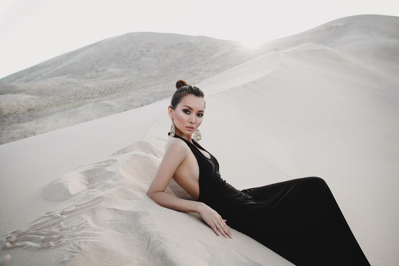 沙漠沙丘上美丽性感的亚洲女人的专业摄影