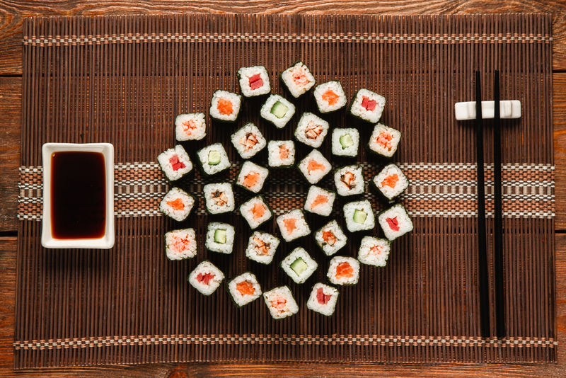 日本美味的大寿司套装，铺在棕色草席上，平放。传统和健康的海鲜美食，美食艺术，餐厅菜单照片。