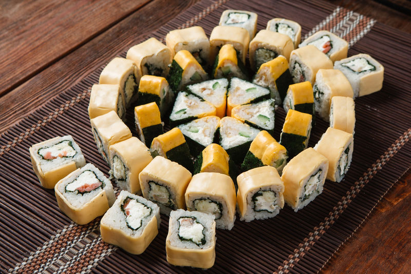 美味可口的开胃寿司套装，放在草席上，俯视图。美食艺术，多彩马赛克，餐厅菜单照片。日本传统海鲜。