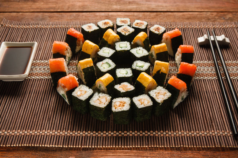 色彩鲜艳的日本寿司套装，棕色草席上的卷形装饰，特写。日本美食艺术，民族美食，餐厅菜单照片。