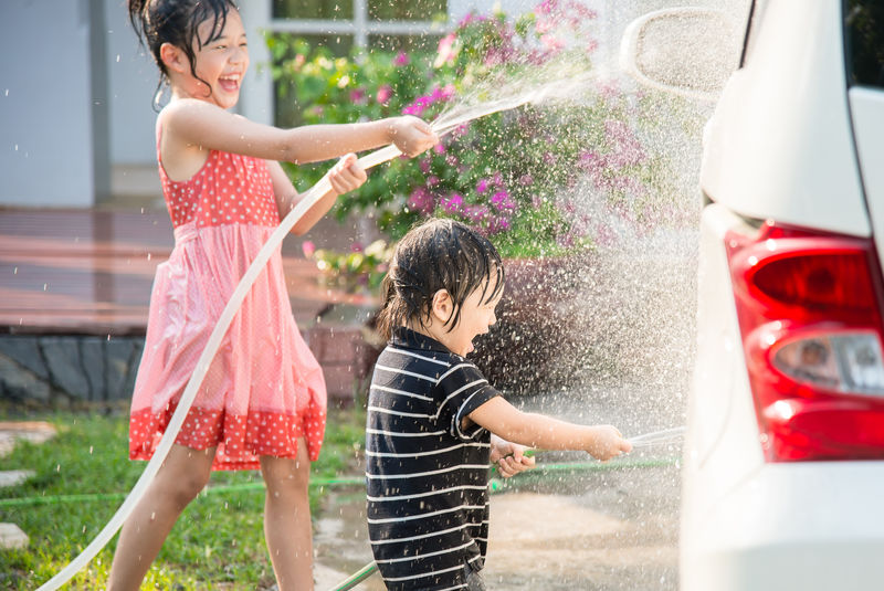 亚洲儿童在花园洗车