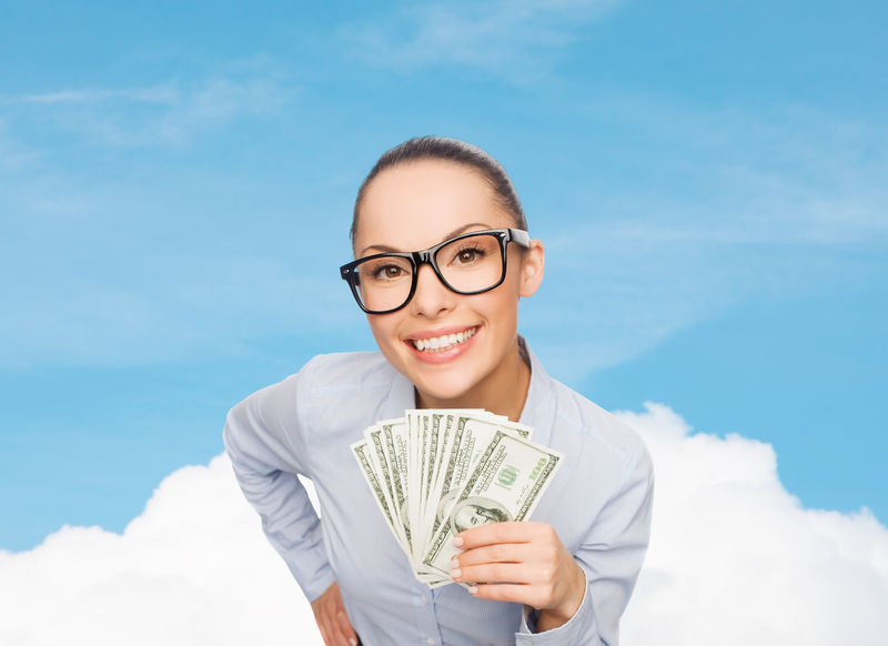 商业、货币和银行概念-戴着眼镜的微笑女商人-带着美元现金-在蓝天白云的背景下