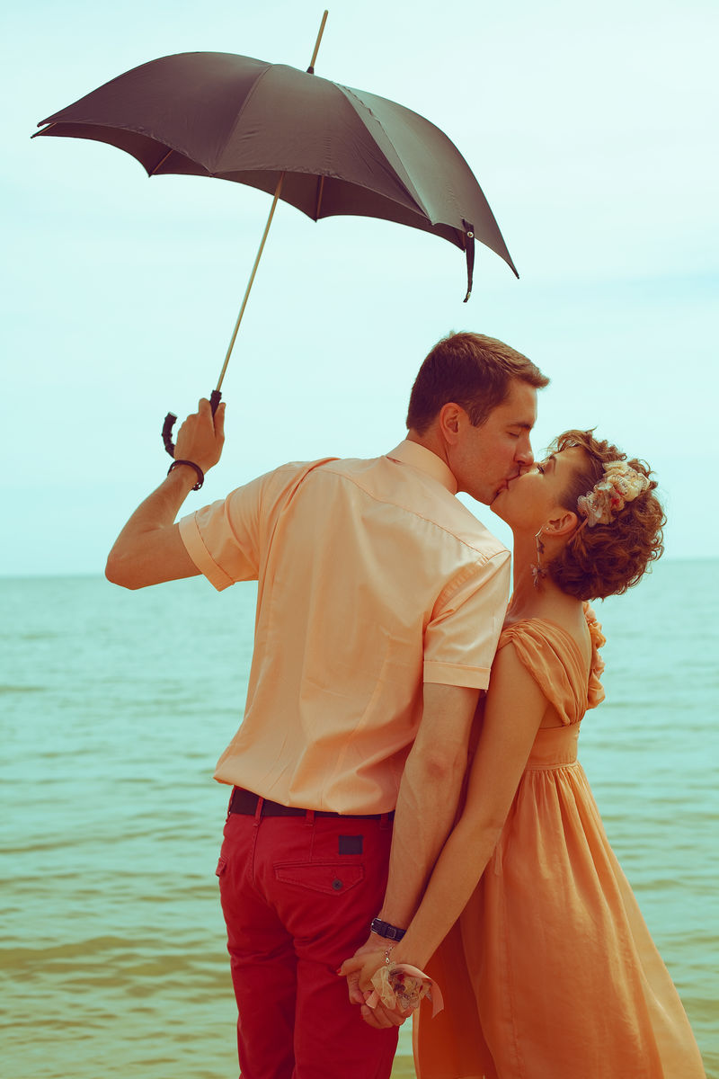 暑假概念。一对站在沙滩上亲吻的夫妇