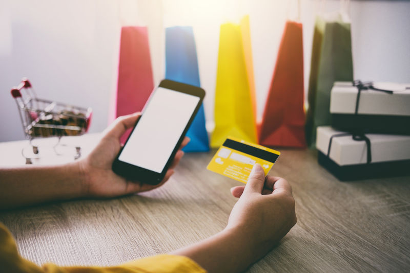 年轻女性使用智能手机进行网上购物网站和信用卡支付、网上支付和购物理念的形象