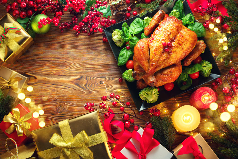圣诞晚餐-烤鸡肉-提供寒假餐桌-用蜡烛和圣诞饰品装饰-木底烤火鸡-配圣诞树-餐桌布置-家庭晚餐-赠送礼物