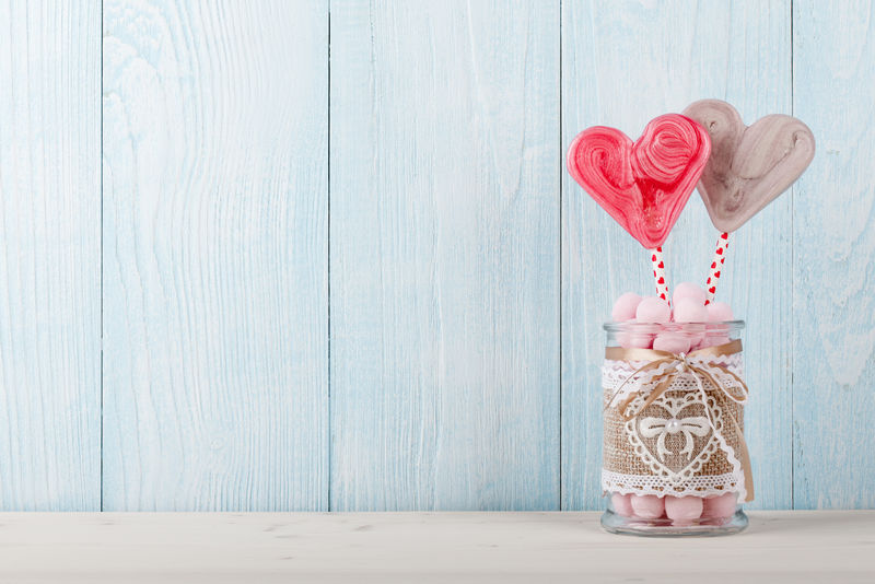 情人节心形棒棒糖和粉色糖果球装在玻璃罐里